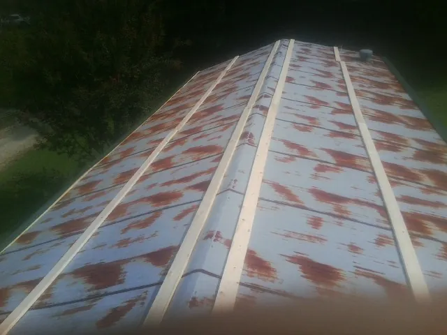 Rusted metal roof panels with new wood purlins before replacement — Storm Damage Roof Repair in Butte by Roofing Brothers