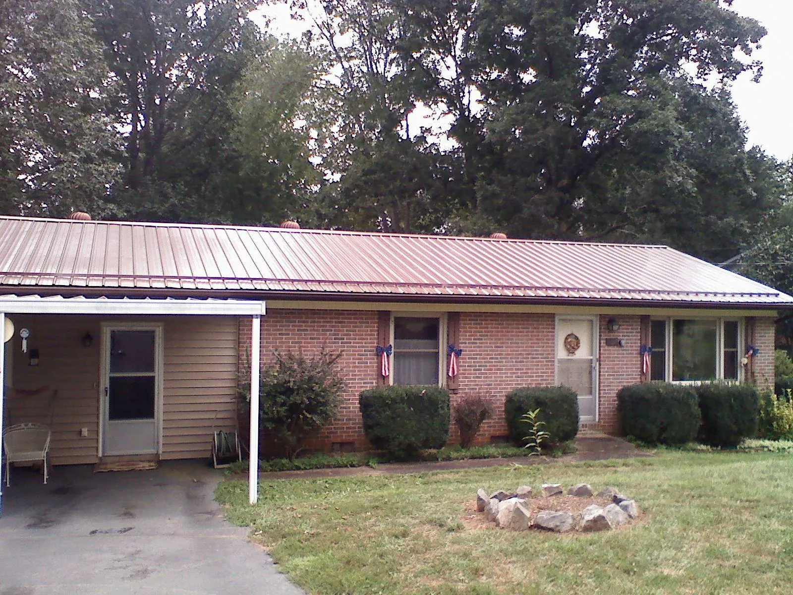 Bronze metal roof and carport on a brick ranch home — Roof Repair work by our crew in Butte
